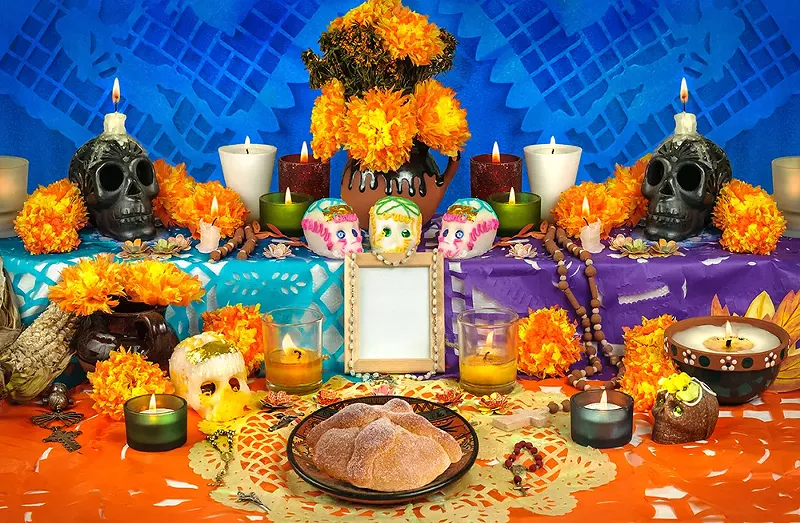 Tokens of departed family members’ favorites are staged at an ofrenda. - Shutterstock