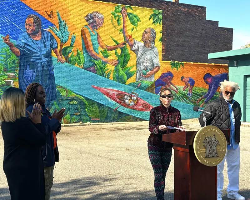 Nicole Macdonald (center right) at the celebration of her new mural, the 200th installation in Detroit's City Walls program. Activist Wayne Curtis (far right) is depicted in the mural. - Randiah Camille Green