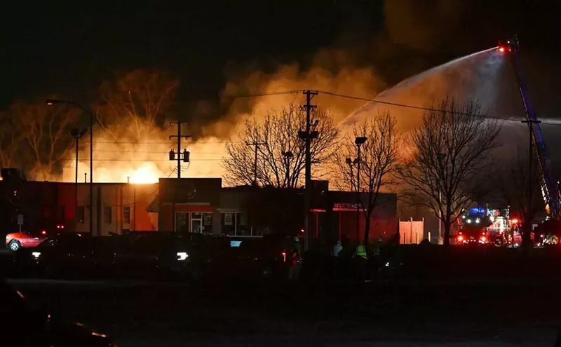 Fire departments battle an industrial fire near 15 Mile Road and Groesbeck Highway in Clinton Township on Monday. - Robin Buckson/Detroit News via AP