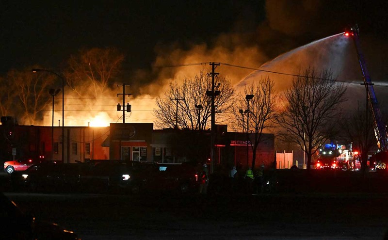 Fire departments battle an industrial fire near 15 Mile Road and Groesbeck Highway in Clinton Township on Monday. - Robin Buckson/Detroit News via AP