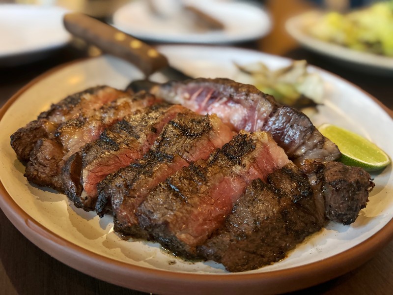 The bone-in ribeye is cooked in a wood-fire hearth at Vecino. - Steve Neavling
