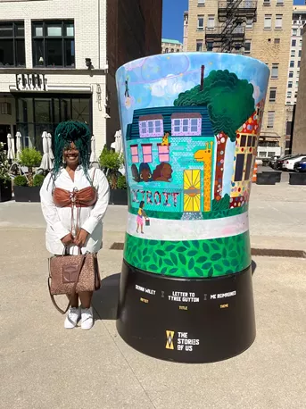 Detroit artist DeAnn Wiley stands next to her sculpture “Letters to Tyree Guyton.” - Layla McMurtrie