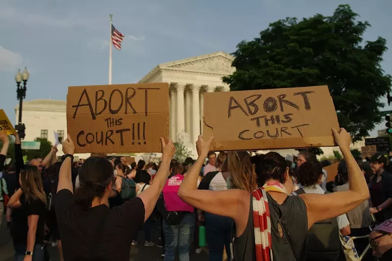 Pro-choice demonstrators hold up signs at a protest at the U.S. Supreme Court. - Shutterstock