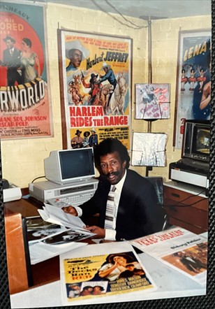 James E. Wheeler at his desk in 1986, surrounded by vintage Black film posters. - Courtesy photo