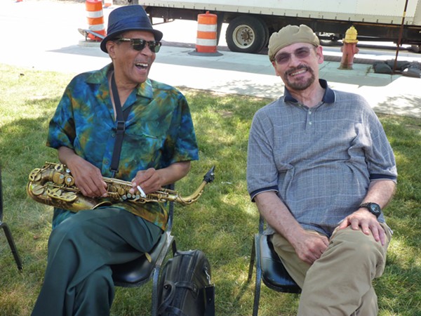 SAX PLAYER LARRY SMITH ON THE LEFT, SEATED WITH UNIDENTIFIED SMILING PERSON, AT 2016'S MAKE MUSIC DETROIT. PHOTO BY NANCY GILLILAND.