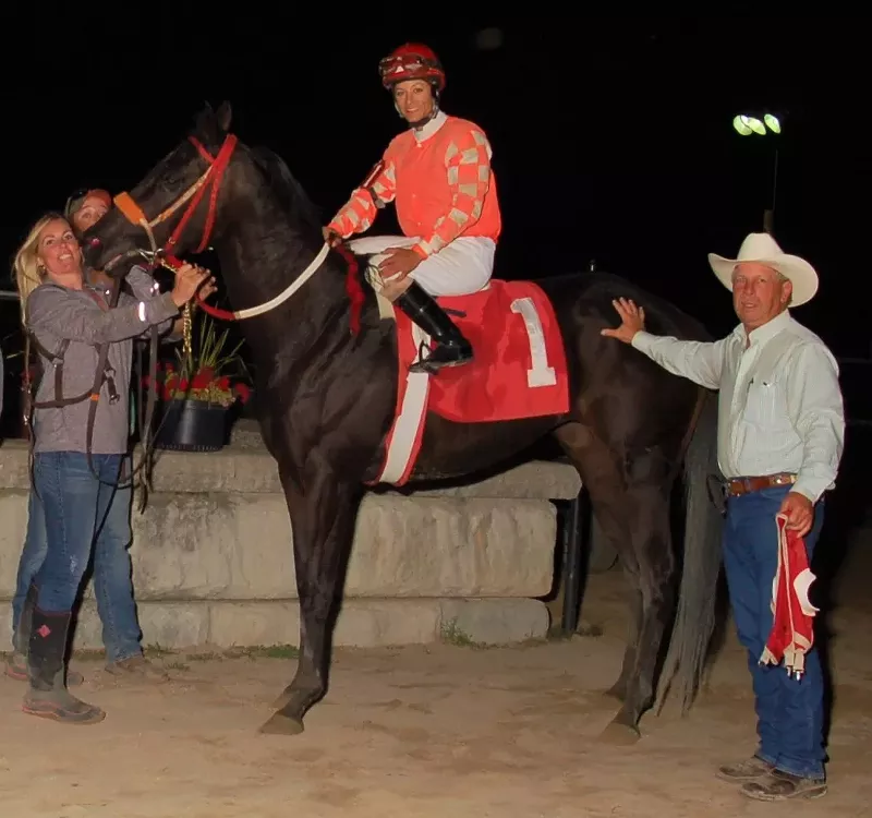 Jockey Melissa Zajac aboard Say Shesnotperfect, with trainer Shane Spiess (right) and assistant trainer Rebecca Tanis (left). - Photo by Curt Porath
