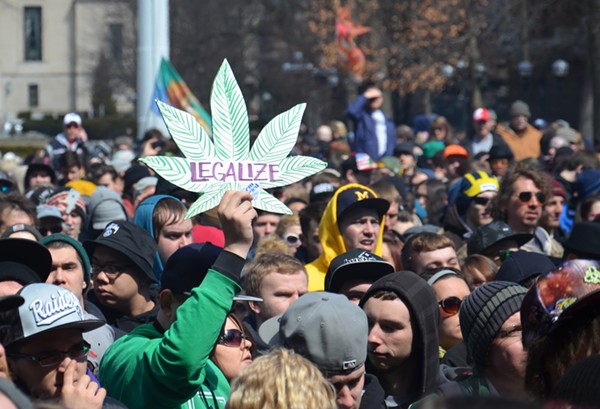 A man holds up a "Legalize" sign at the 43rd annual Hash Bash rally in Ann Arbor.
