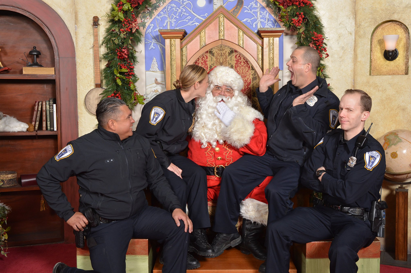 Troy police officers cozy up  to Santa Claus in a photo posted to the department's Twitter account. - Troy Police Department