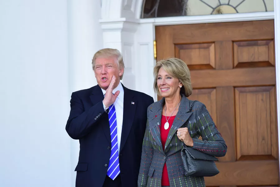 Then-President-elect Donald Trump meets with Betsy DeVos in Bedminster, N.J. in 2016. - A. Katz