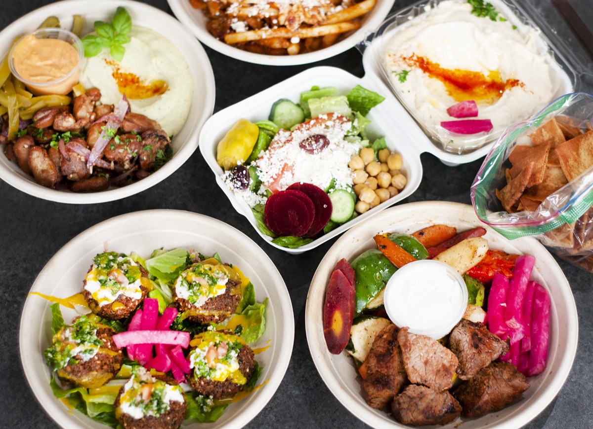 Counterclockwise bottom left to right: Loaded falafel, fooul, shawarma fries, hummus, beef tenderloin bowl, and salad.