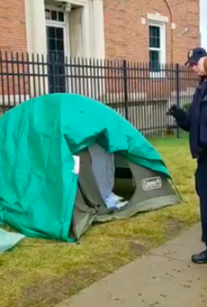 An officer with Homeland Security’s Federal Protective Services Police prepares to take down the remaining tents in Detroit's Occupy ICE encampment.