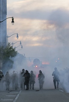 Detroit police deploy tear gas and rubber bullets as protesters flee.