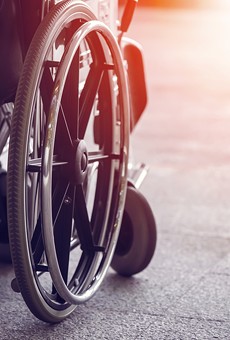 A local activist in a wheelchair has filed suit against a municipal lawyer over demeaning emails.