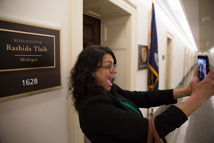Congresswoman Tlaib arrives at her new office for the first time to livestream on social media and share with her constituents. Immediately after, she snaps a selfie in front of her office’s placard. - ERIK PAUL HOWARD