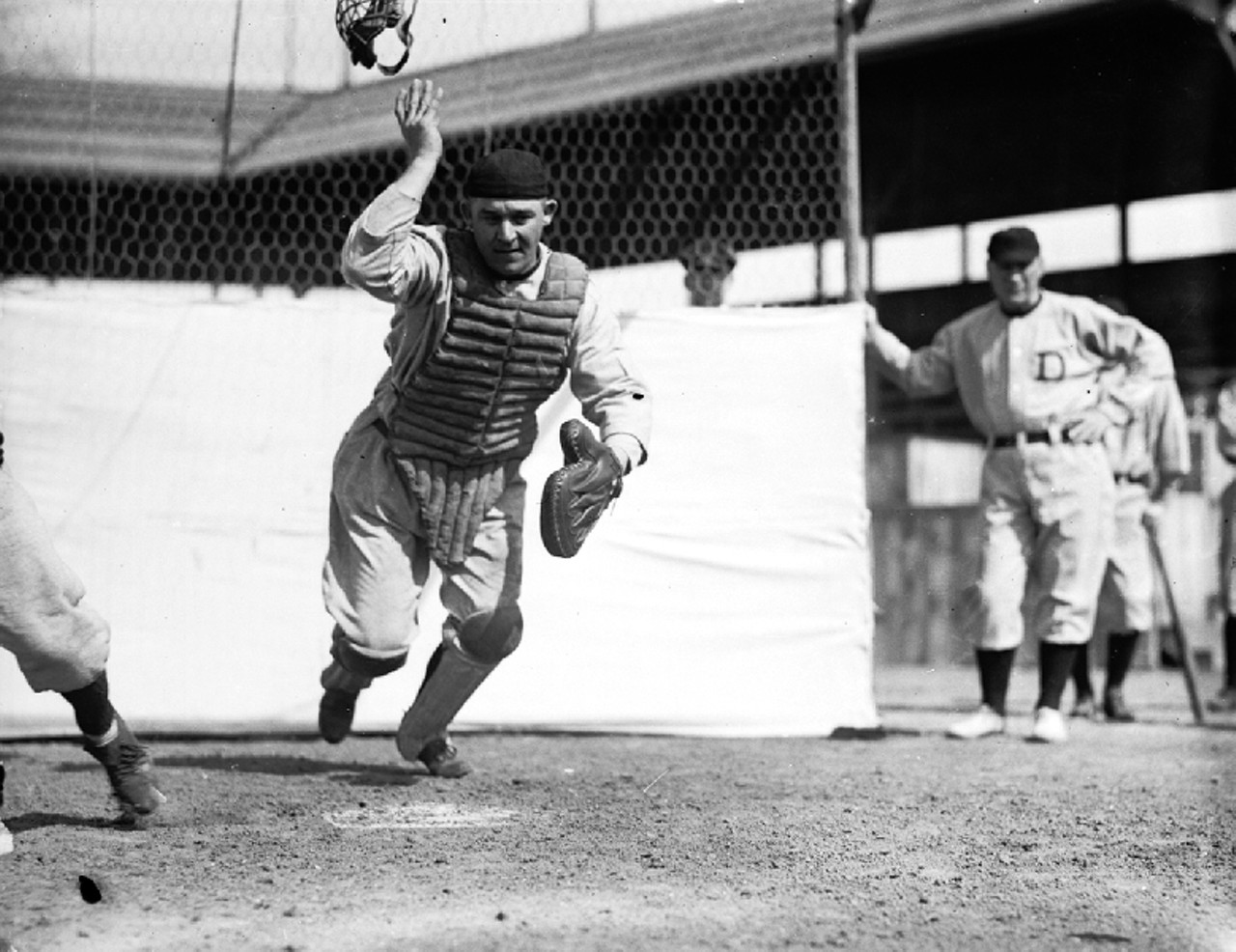 Catcher Oscar Stanage flips off his mask to chase a ball at Navin Field in the 1920s.