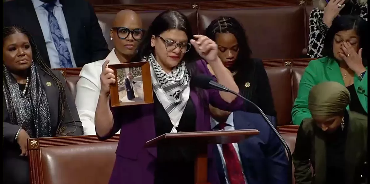 Image: U.S. Rep. Rashida Tlaib holds up a photo of her Palestinian grandmother on the House floor.