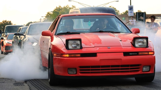 An old Toyota doing burnout at Woodward Dream Cruise.