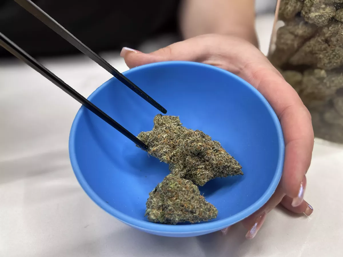 A budtender shows off some Mi Loud flower from the deli at Supergood Detroit.